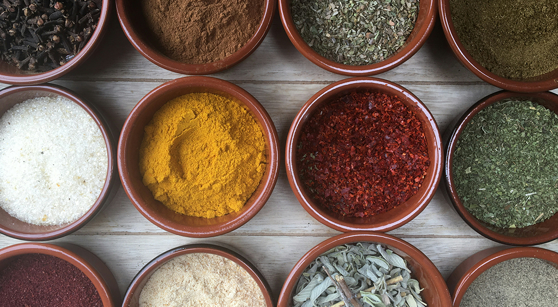 Bild von ayurvedischen Gewürzen in rötlichen Tonschalen